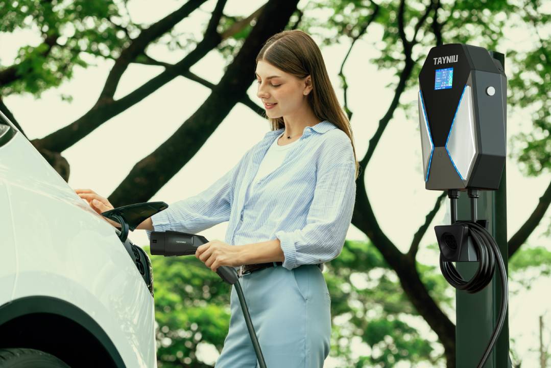 A woman is charging her car with a Level 2 electric car charger