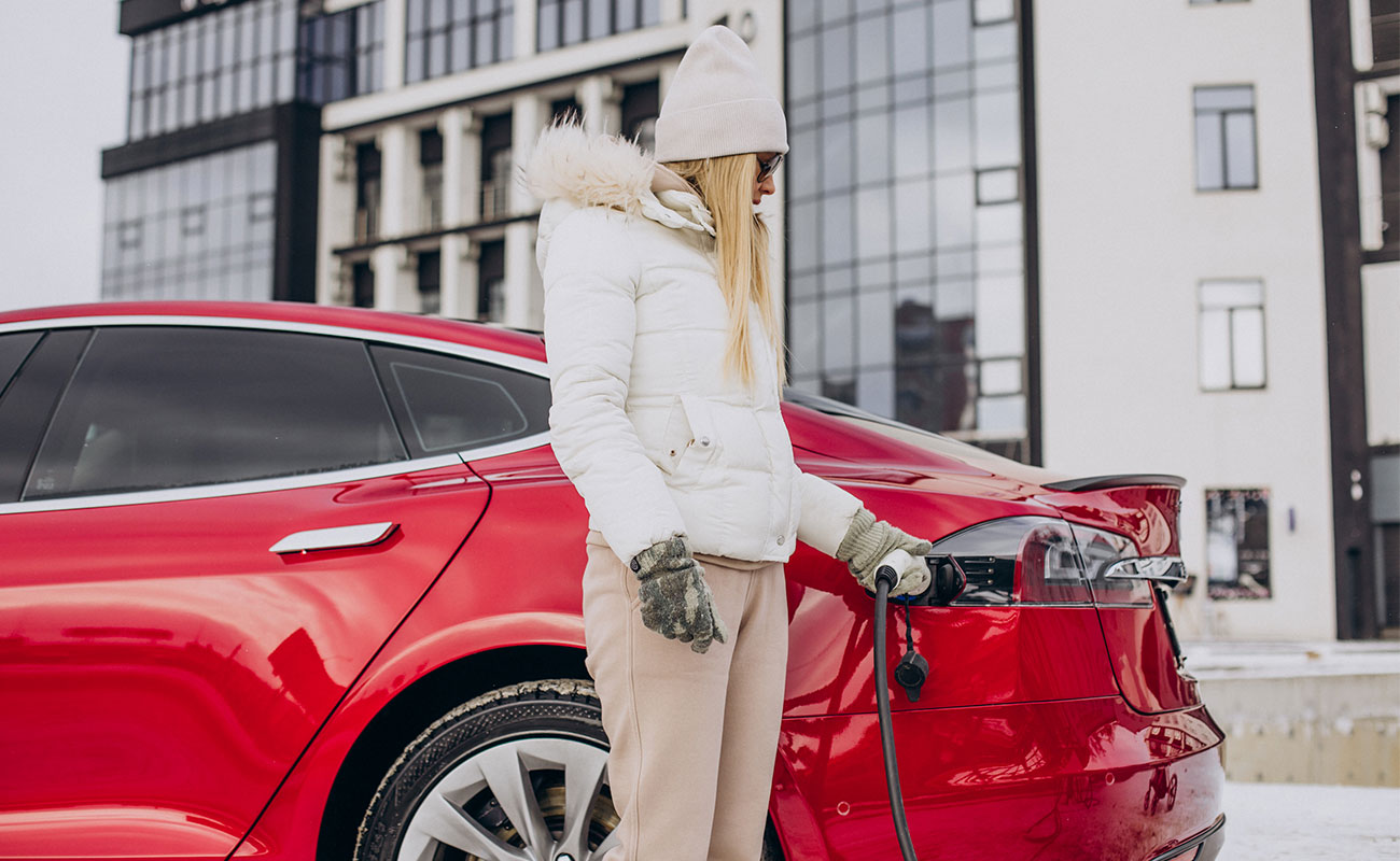 A woman is charging a rented Tesla.