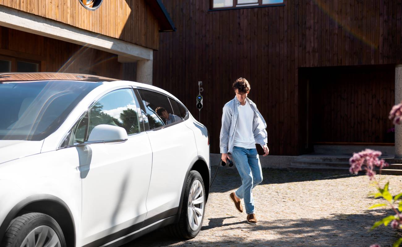 A man in a hotel is about to use a Type 2 electric car charger to charge his car.