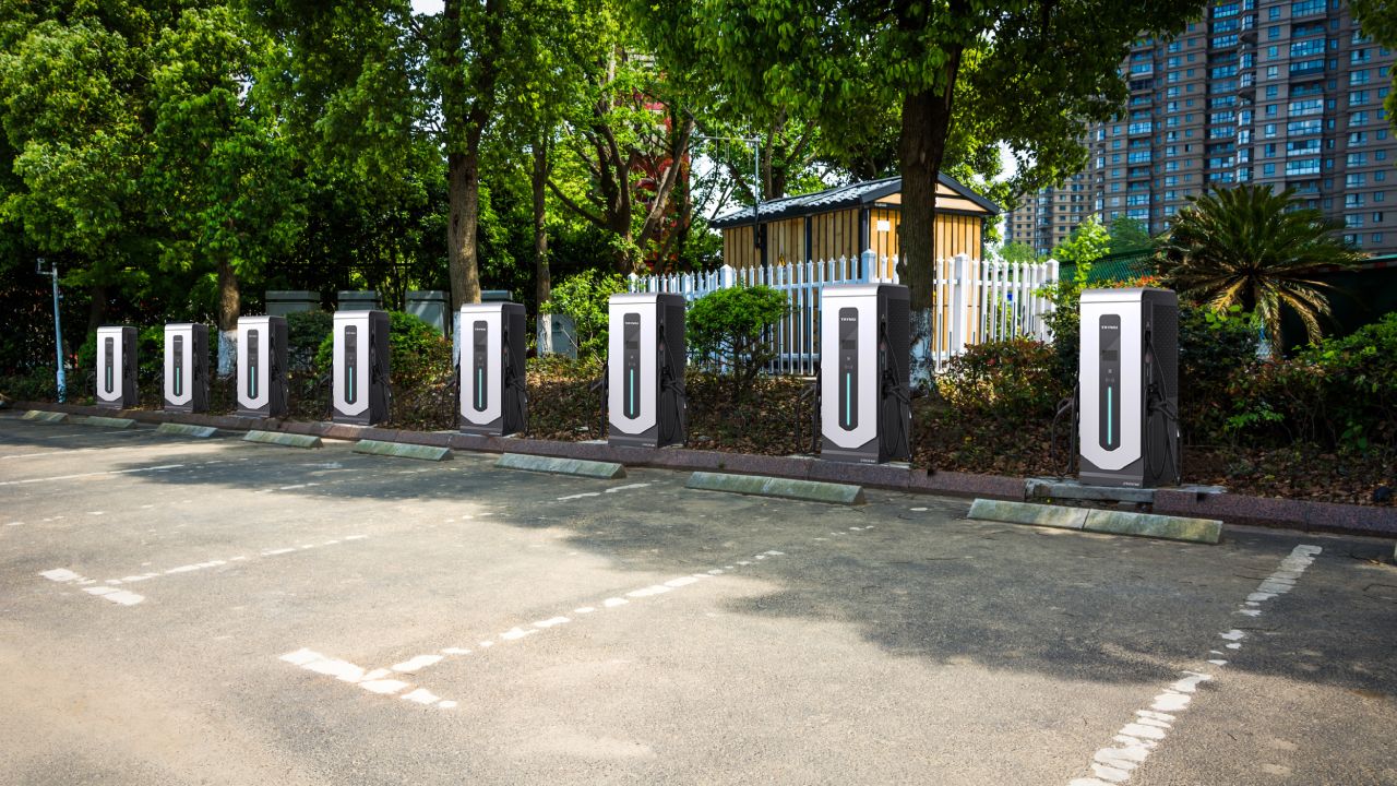 Row of commercial charge stations in a parking lot designed for electric vehicles, showcasing advanced EV charging infrastructure.