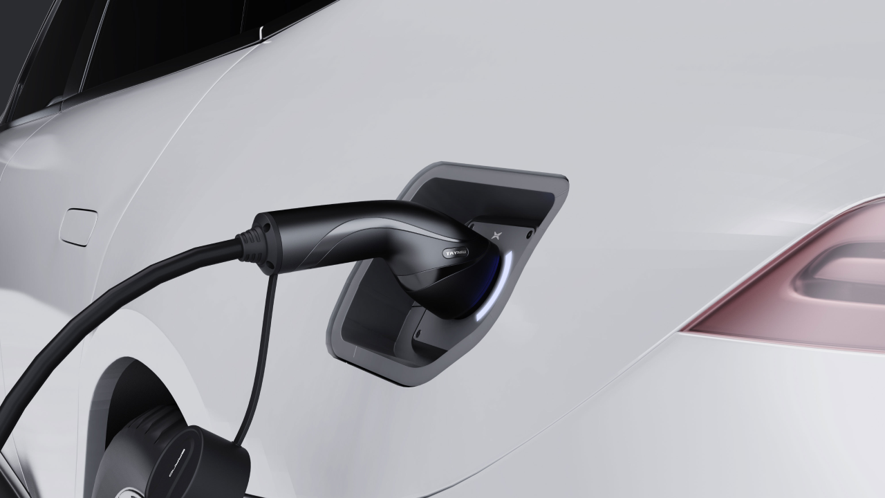 Close-up of a Tayniu EV charger connected to an electric vehicle, showcasing a sleek charging handle and Type 2 interface.