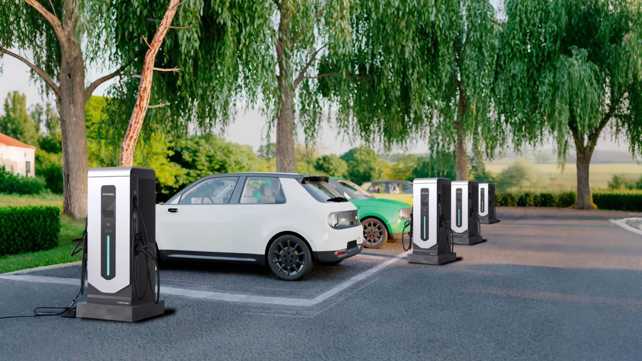 Commercial EV chargers by Tayniu installed in a green parking lot with multiple electric vehicles charging.