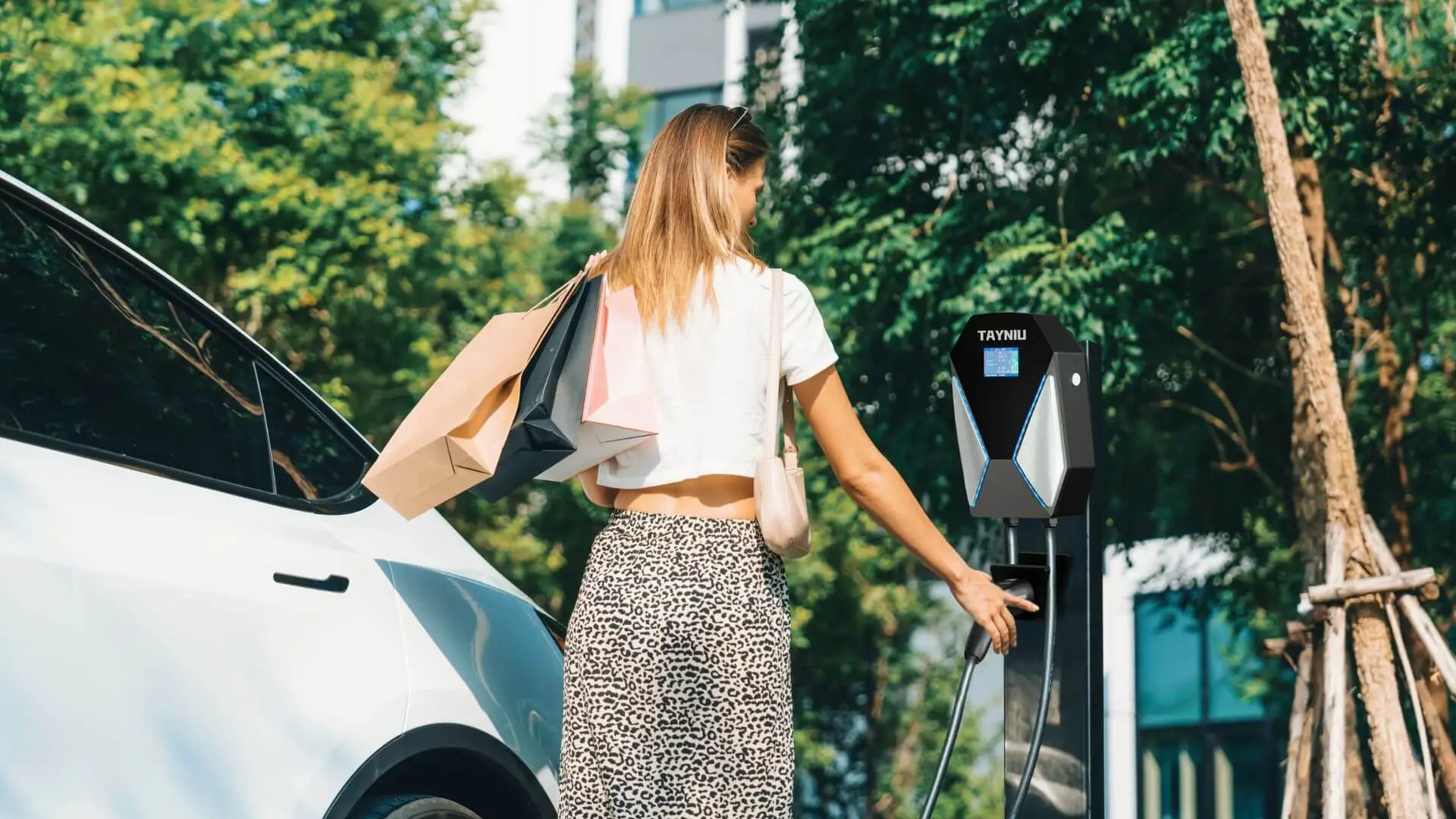 A woman using a Tayniu EV charger at a shopping mall, showcasing modern EV charging business models that attract more customers and increase revenue.